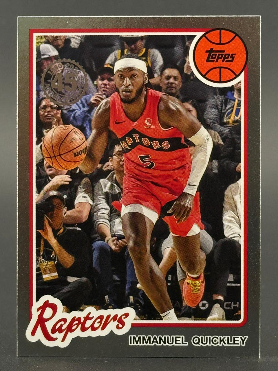 Immanuel Quickley 2023-24 Topps basketball card, featuring him dribbling in a red Raptors uniform.