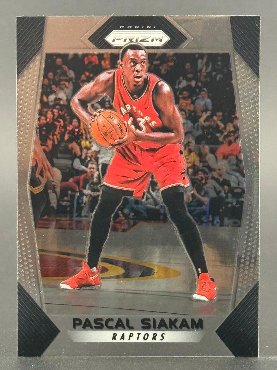 Pascal Siakam basketball card, Panini Prizm, featuring him in a red Raptors uniform holding a basketball.