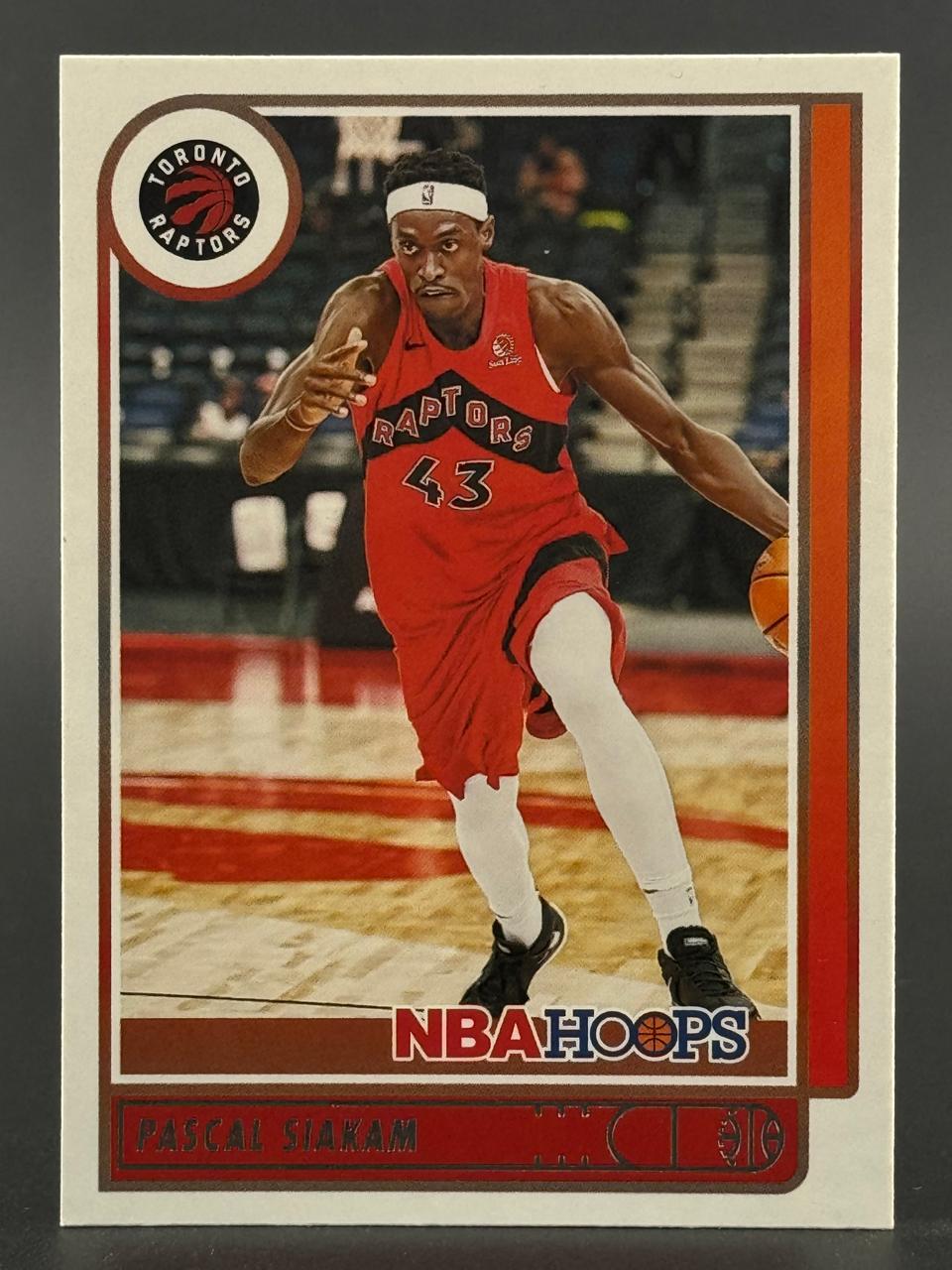 Pascal Siakam basketball card from NBA Hoops, showing him dribbling in a red Raptors uniform.