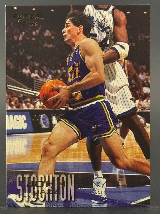 1996-97 Fleer John Stockton trading card featuring him dribbling in a Utah Jazz uniform.