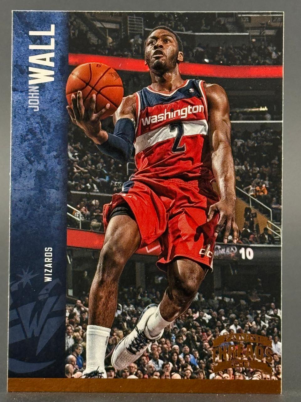 2012-13 Panini Threads John Wall basketball card featuring Wall in a red Washington Wizards uniform holding a ball.