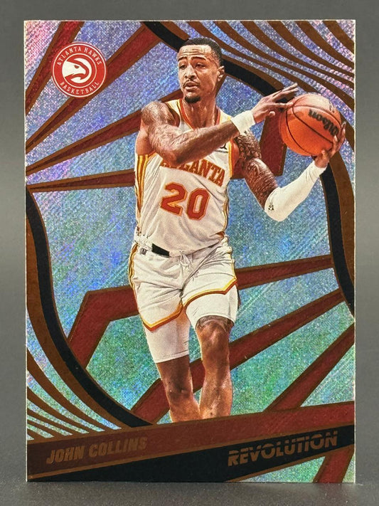 John Collins Revolution basketball card, showing him in an Atlanta Hawks uniform holding a basketball.