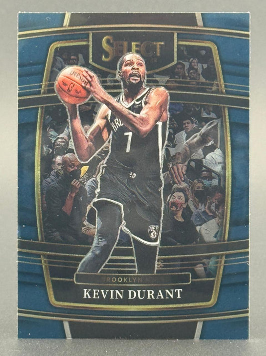 Kevin Durant 2021-22 Panini Select basketball card holding a basketball in a Nets uniform.