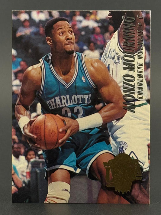 Trading card of Alonzo Mourning in a Charlotte Hornets uniform holding a basketball.
