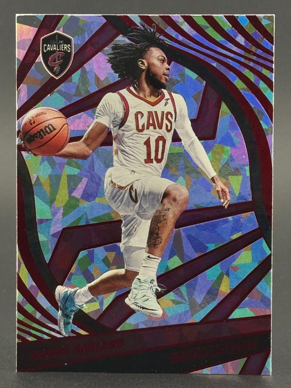 Darius Garland trading card featuring him in a Cavaliers uniform, holding a basketball against a geometric background.