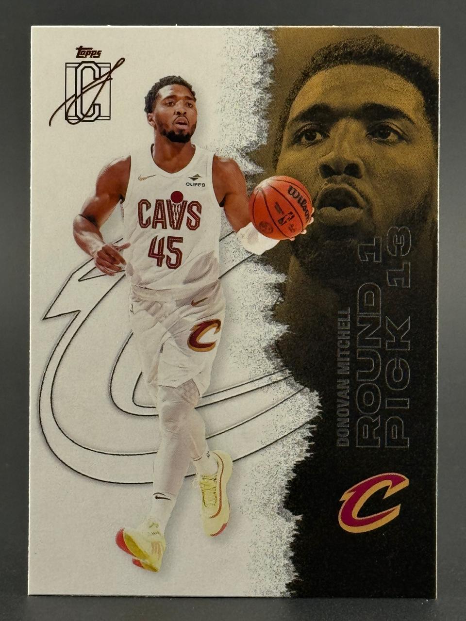 Donovan Mitchell trading card showing him in a Cleveland Cavaliers uniform holding a basketball.