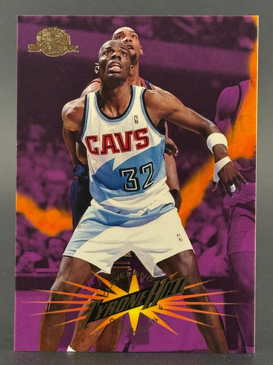 Basketball card of Tyrone Hill in a Cavaliers jersey, set against a purple background with orange lightning graphic.