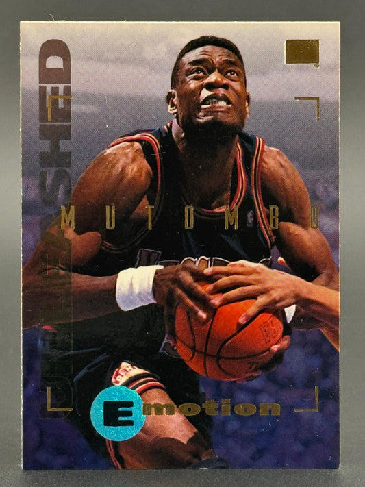 1994-95 SkyBox E-Motion Dikembe Mutombo trading card featuring him holding a basketball.