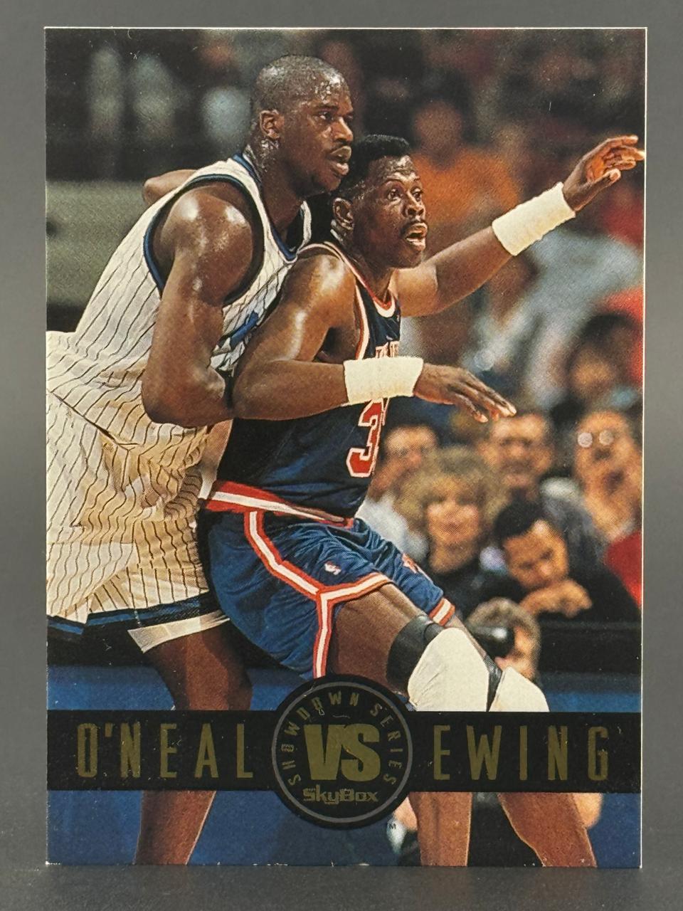 Shaquille O'Neal and Patrick Ewing on a SkyBox Showdown Series basketball trading card.
