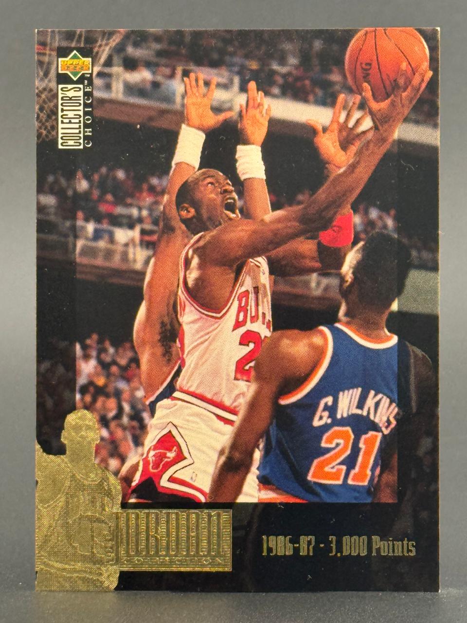 Michael Jordan 1986-87 Collector's Choice basketball card, showing him driving to the basket with a defender.