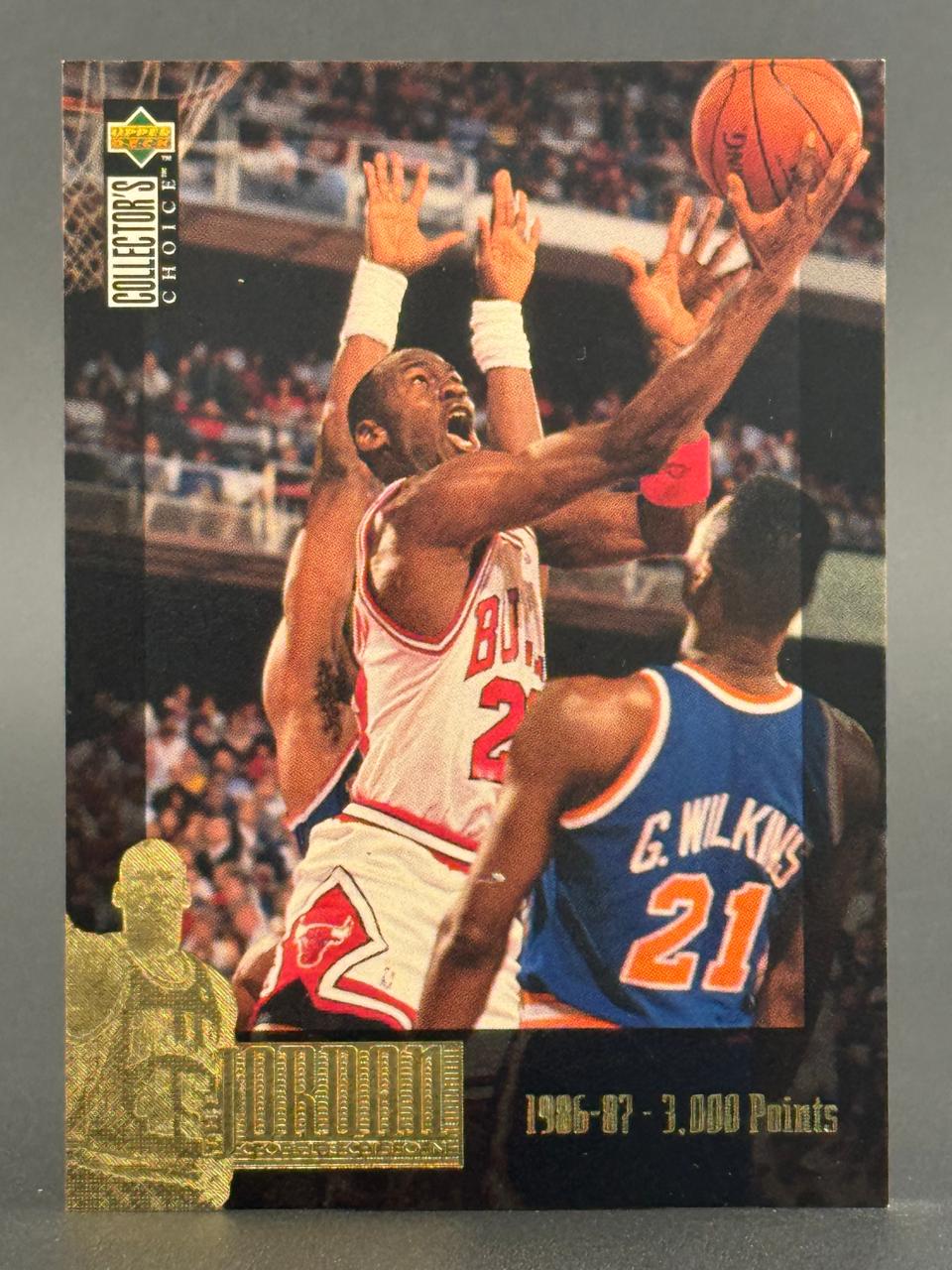 Michael Jordan 1986-87 Upper Deck Collector's Choice trading card featuring Jordan driving against Gerald Wilkins.