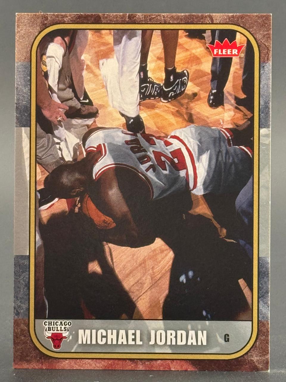 Michael Jordan trading card showing him prone on the court with a Fleer logo and Chicago Bulls team name.